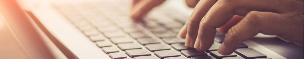 Close-up of hands typing at keyboard